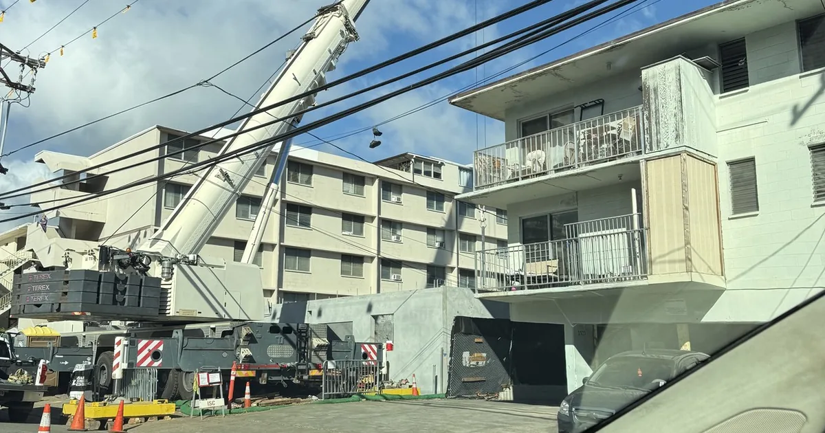 Aging low-rise walk-up apartment building in urban Honolulu seen from the street