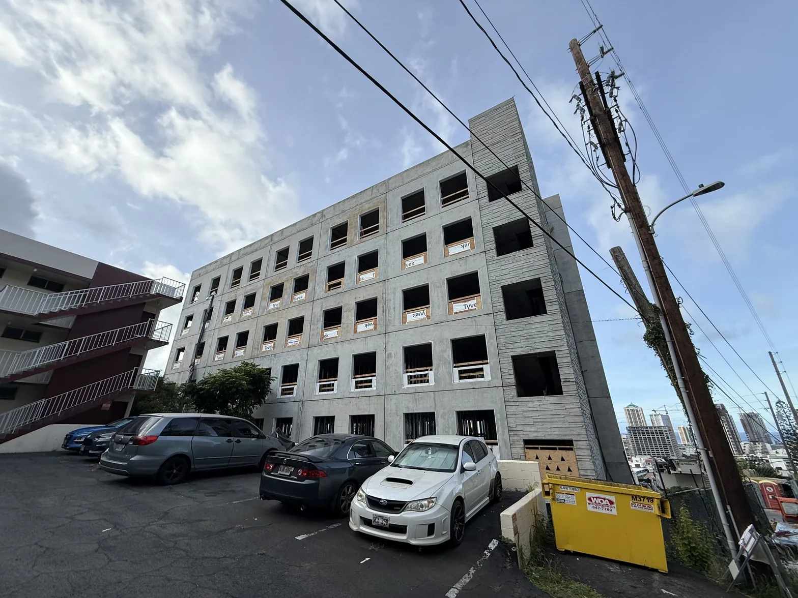 Concrete structure of an Oceans Real Estate residential project under construction in Honolulu with crew on site